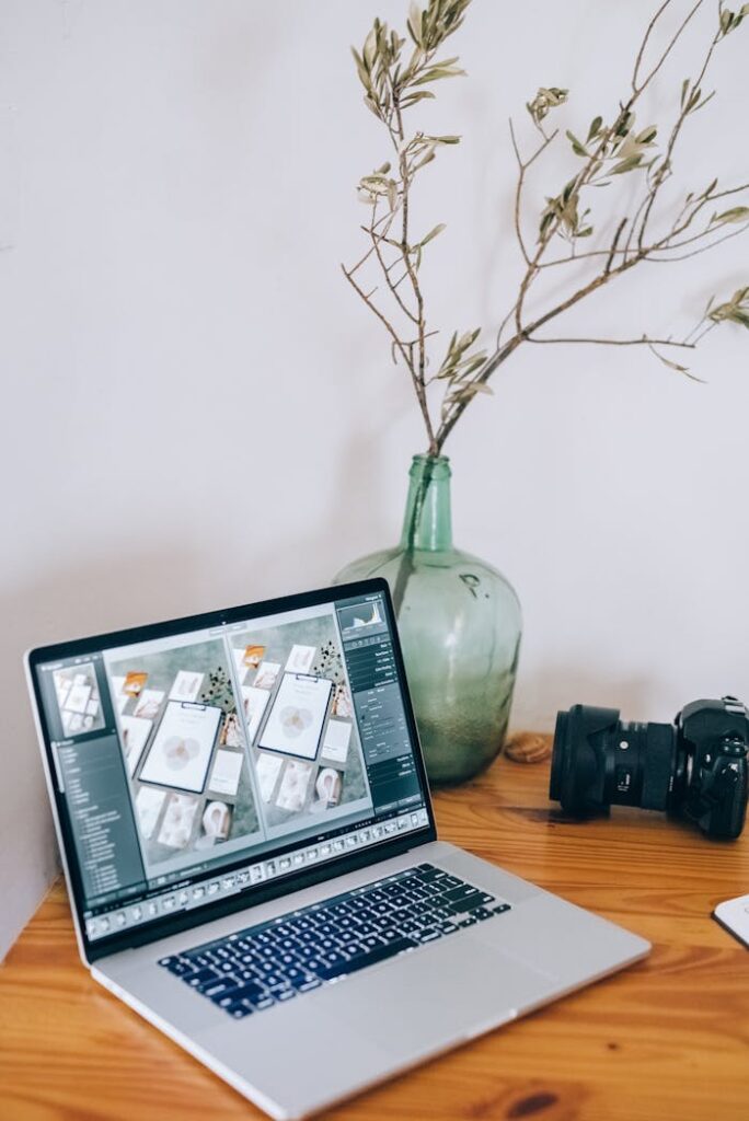 A Laptop and a Camera on a Wooden Table